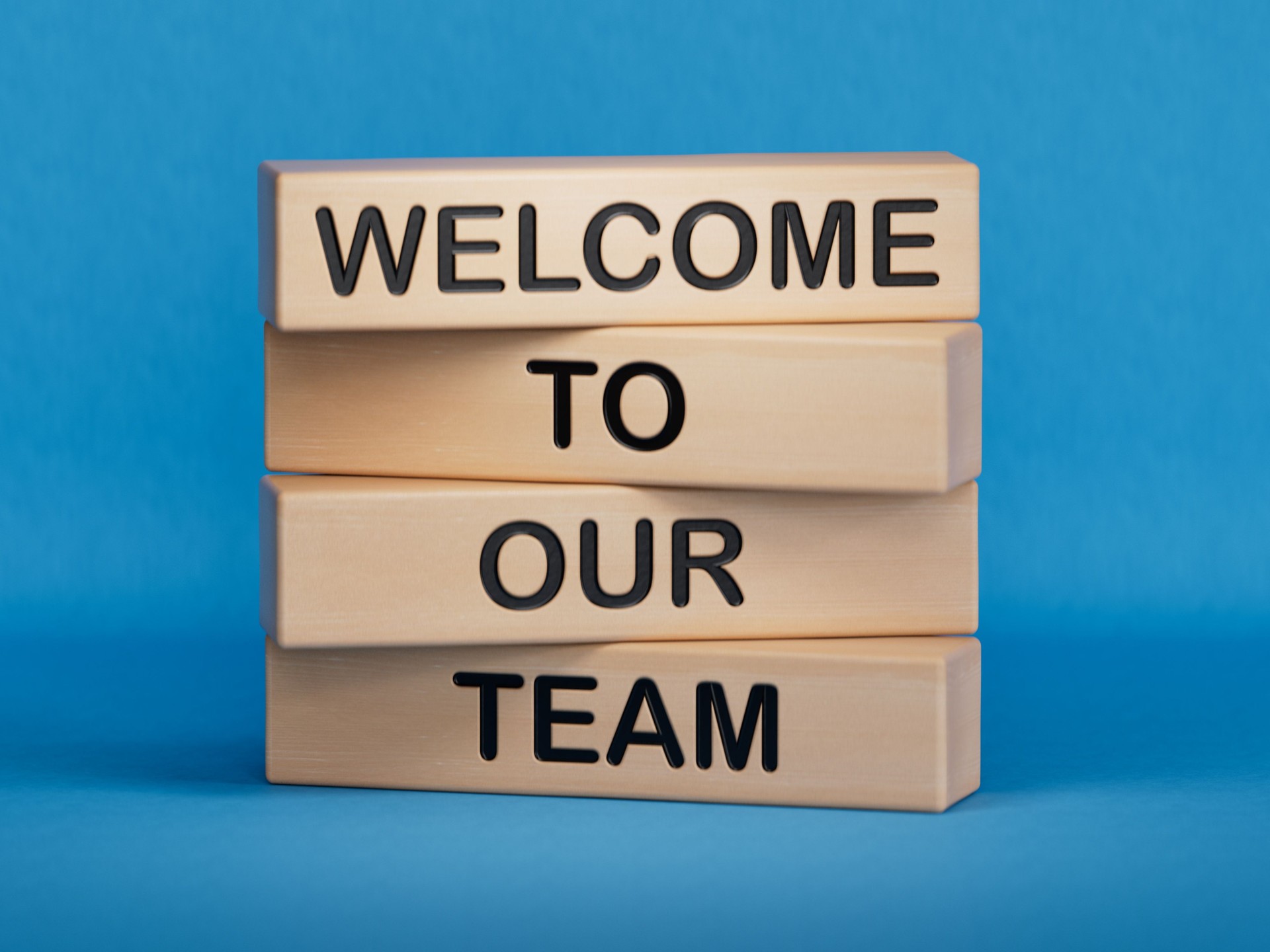 Welcome to our team symbol. Concept words Welcome to our team on wooden blocks. Businessman hand. Business, motivational and welcome to our team concept.3D rendering on blue background.